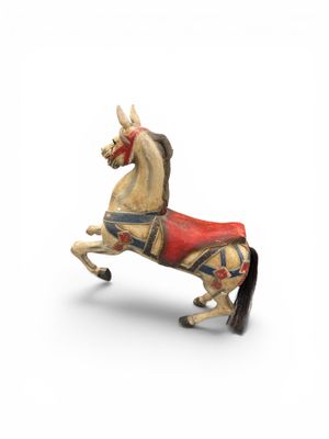 statue d'un cheval avec une selle sur le dos, sur fond blanc