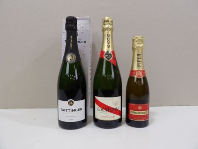 trois bouteilles de champagne et une boîte de vin posées sur une table