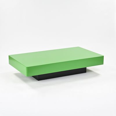 une table basse verte avec un piètement noir sur fond blanc