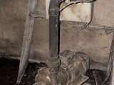 a dirty pipe in the corner of a room
