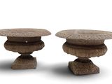two stone vases sitting side by side on a white surface