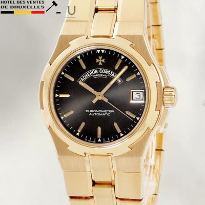 a gold wrist watch with a black dial on a gold bracelet