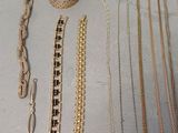 many different types of necklaces and bracelets laid out on a table