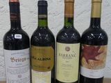 quatre bouteilles de vin sont alignées sur une table en bois