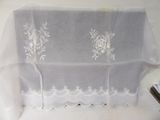 une nappe blanche à motifs floraux, avec une paire de ciseaux à côté