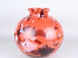 a red vase with a black and white design on it