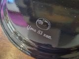 a black lid on a black plate on a wooden table