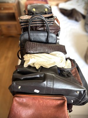 une pile de sacs à main posée sur un lit