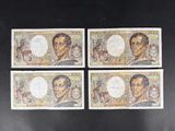 quatre types différents de billets de banque sur lesquels figurent des portraits d'hommes