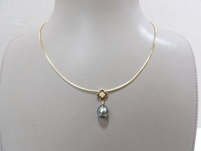 Collier plaqué or orné d'une perle grise, présenté autour du cou d'un mannequin
