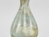 a green vase that is sitting on a table