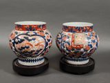 une paire de vases chinois posés sur des socles, sur un fond gris