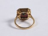 an image of a gold ring with a garnet stone in the center