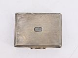 an antique silver cigarette case on a white surface