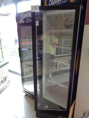 un homme debout devant un réfrigérateur dans un magasin