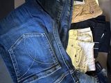 several pairs of men ' s jeans stacked on top of each other