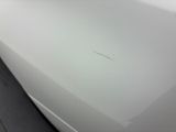 a close up of a white car with a hole in it
