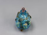 une petite bouteille en verre bleue ornée d'un motif floral