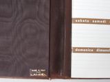 a brown leather folder with a notepad inside of it