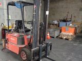 a forklift in a warehouse with pallets and boxes in the background