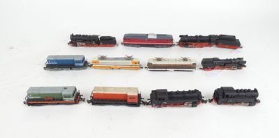 several toy trains are lined up in a row on a white surface