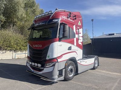 un semi-remorque rouge et blanc garé sur un parking