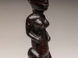 une petite statue en bois représentant un homme à la grosse tête