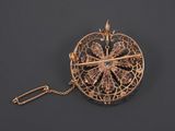 a close up of a gold broochle with a chain around it