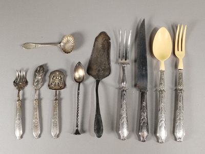 beaucoup d'argenterie sur une table avec des cuillères et des couteaux