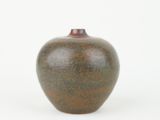 a brown vase sitting on a white surface with a white background