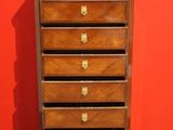 an old wooden chest of drawers against a red wall