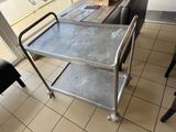 un chariot métallique posé sur un sol carrelé devant une fenêtre