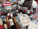 une statue représentant un homme tenant une bouteille de bière à côté de bouteilles de bière