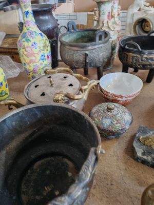 de nombreux vases et bols sont posés sur la table dans cette pièce