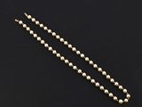 a gold beaded necklace on a black background