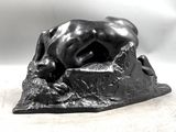 statue of a dog resting on a rock on a white background
