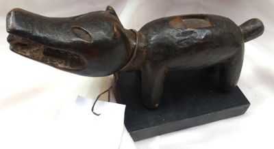 une petite statuette représentant un chien avec une médaille autour du cou