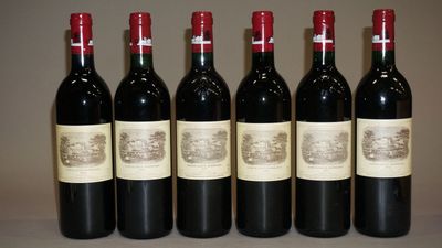 six bouteilles de vin sont alignées sur une table