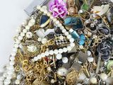 a pile of assorted jewelry on a white surface