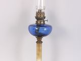 une lampe en verre bleu avec un pied doré sur fond blanc