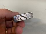a person holding a silver ring that has a picture on it