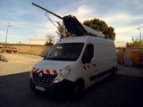 une camionnette blanche garée sur un parking, avec une grue sur le toit
