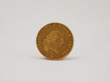 a close up of a gold coin on a white surface