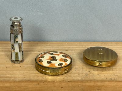 un petit objet métallique posé sur une table à côté d'un briquet