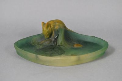 a small figurine of a cat on a plate