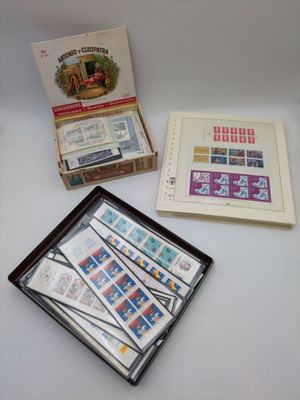 two boxes of stamps are sitting on a table next to a box of stamps