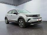 a silver car is parked in a white room with a black floor