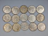 a group of silver coins sitting on top of a white surface