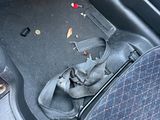 the interior of a car with a broken seat belt and a broken boot