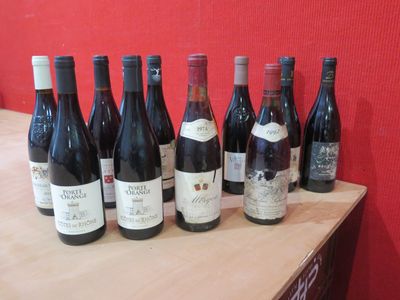 des bouteilles de vin rouge alignées sur une table devant un mur rouge
